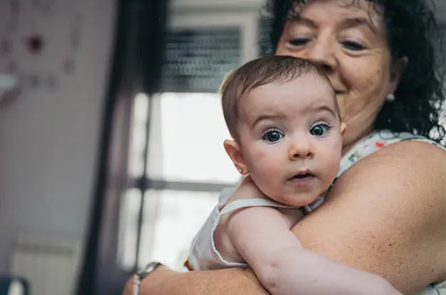 Senhora segura carinhosamente uma bebê. - Mustela Brasil - 1