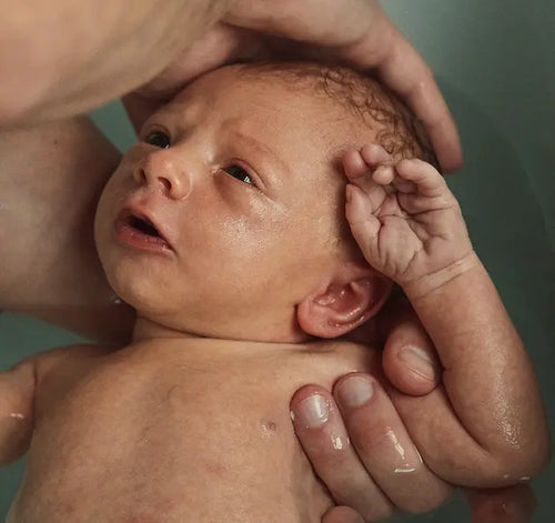 Pai dando banho em bebê recém-nascido. - Mustela Brasil - 1