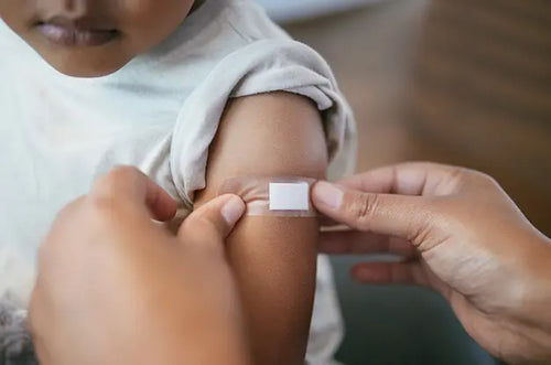 Mãe colocando curativo em braço de criança. - Mustela Brasil - 1