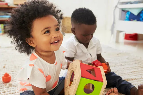 Menina e menino brincam juntos sentados no chão. - Mustela Brazil - 1