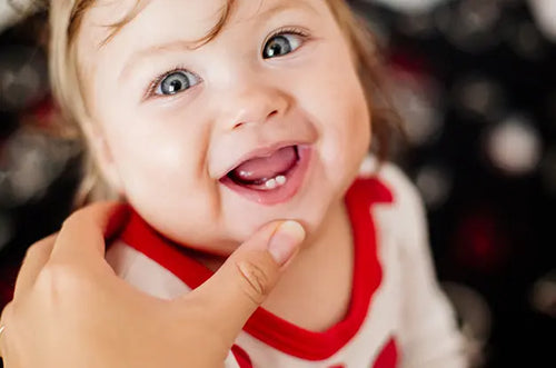 Bebê sorridente mostrando os 2 primeiros dentinhos. - Mustela Brasil - 1