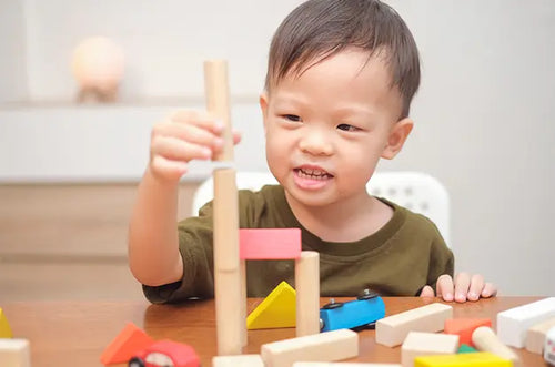 Menino brincando de empilhar brinquedo de madeira. - Mustela Brasil - 1