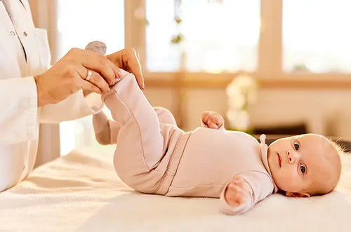 Pediatra segura pezinho de uma bebê curiosa. - Mustela Brasil - 1