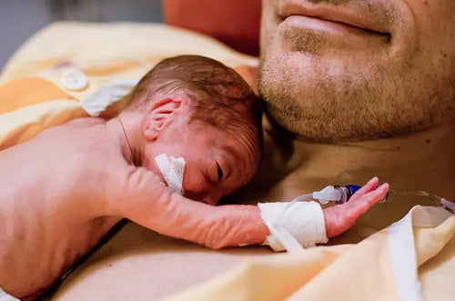 Bebê recém-nascido apoiado no peito do seu pai.  - Mustela Brasil - 1