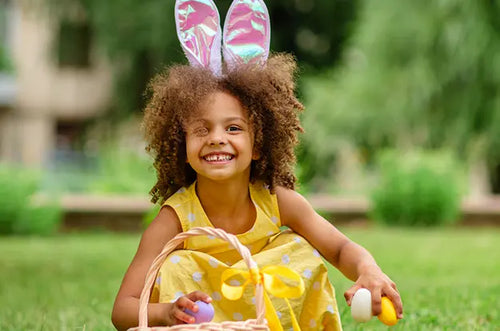 Menina sorridente com tiara de orelhas de coelho brincando de caça aos ovos. - Mustela Brasil - 1