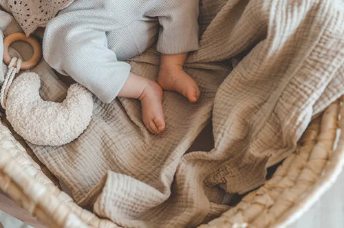 Bebê dentro de berço, a imagem mostra apenas seus pezinhos e a manta no berço. - Mustela Brasil - 1